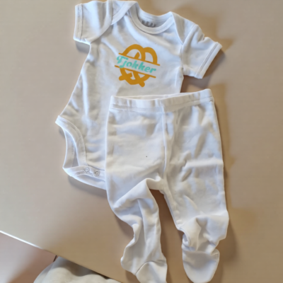 White with yellow pretzel and word "Tjokker" (0-3 Months)